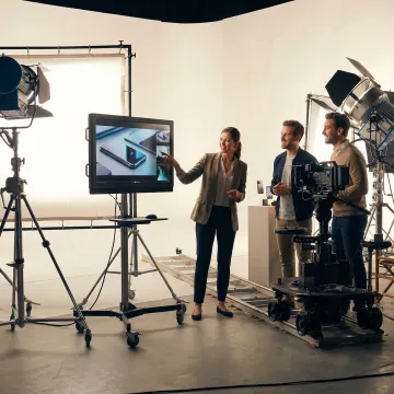 Video production team reviewing e-commerce product footage on a monitor during a studio shoot