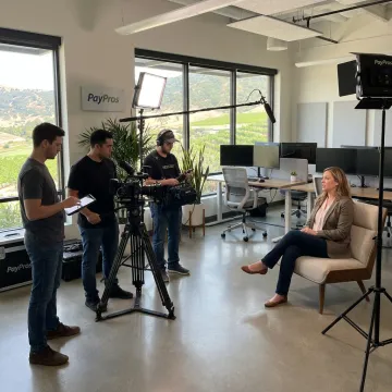 Film crew recording employee interview in modern office