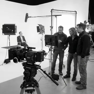 Video production team reviewing footage on set