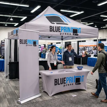 Team using a branded pop up canopy at a trade show