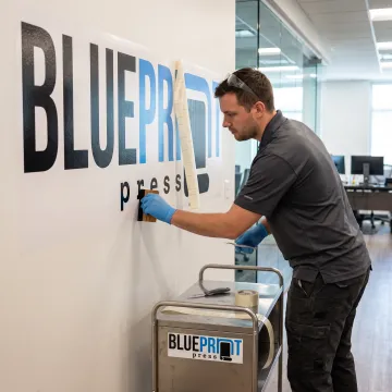 Technician preparing a large vinyl wall graphic