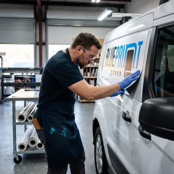 Designer applying a magnetic van sign