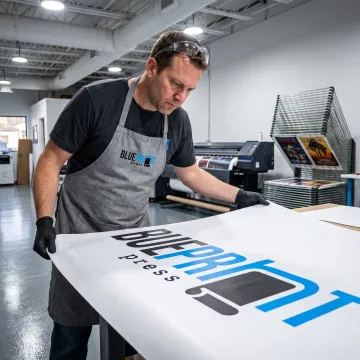 Print specialist reviewing a large-format banner