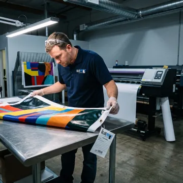 Print specialist reviewing a large custom vinyl banner