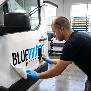 Technician applying a custom vinyl vehicle decal