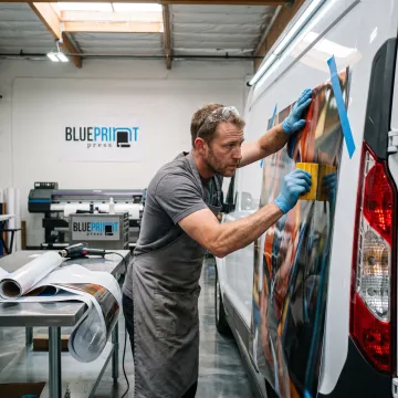Technician applying a custom vinyl vehicle graphic