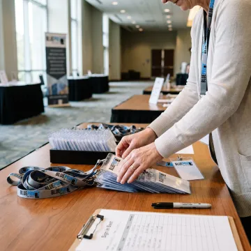 Event organizer preparing branded lanyards and badges