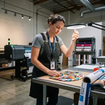 Designer reviewing colorful custom badge artwork
