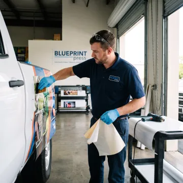 Designer applying vinyl graphics to a work truck