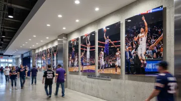 Large format acrylic basketball photography panels installed in sports arena corridor