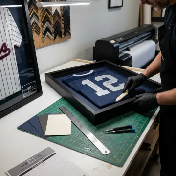Designer arranging a sports jersey for custom framing