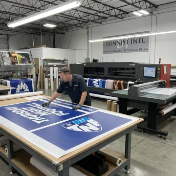 Fabricator reviewing large branded display panels