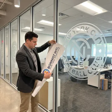 Designer reviewing perforated vinyl window graphics proofs