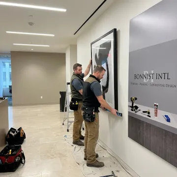Team installing branded artwork in a commercial lobby