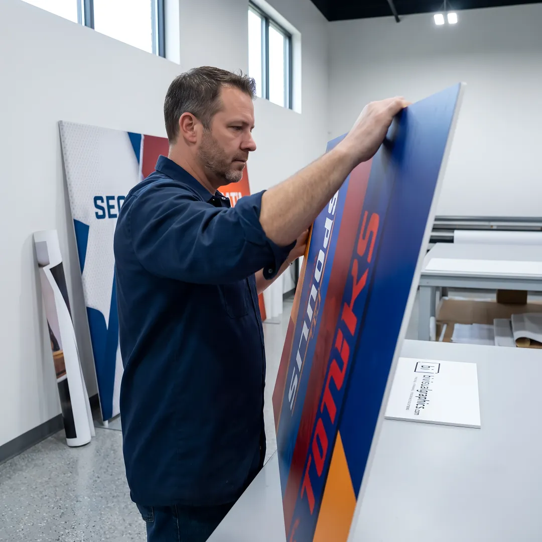 Fabricator reviewing large branded display panels
