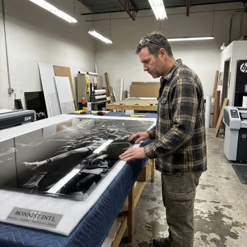 Technician reviewing acrylic wall art prints during production