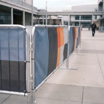 Custom barricade banners installed at a branded event perimeter