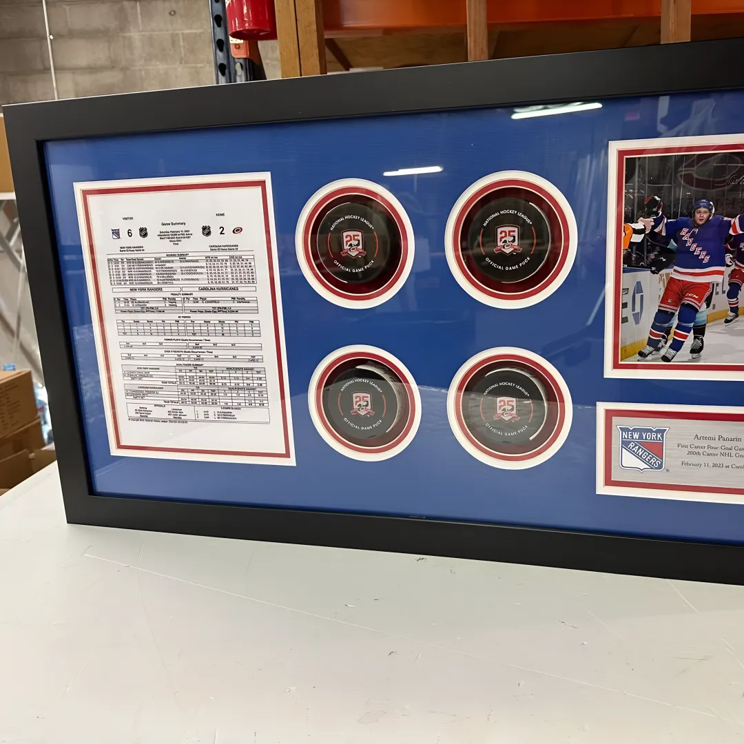 Craftsperson preparing custom sports memorabilia framing