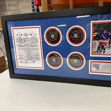 Craftsperson preparing custom sports memorabilia framing