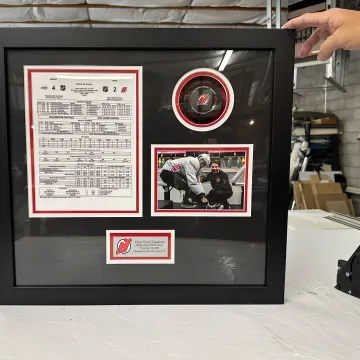 Designer arranging memorabilia inside a custom shadow box