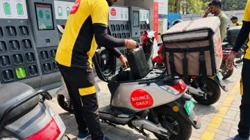 Bounce Daily electric scooter at battery swap station with delivery partner exchanging battery pack