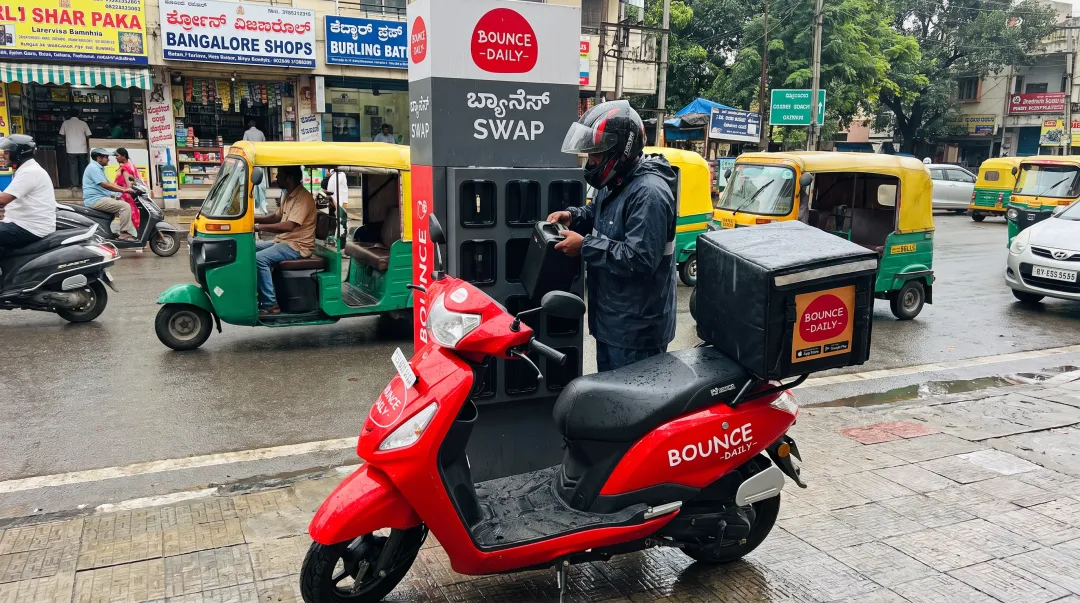 Bounce Daily electric scooter at battery swapping station in Bangalore with delivery bag mounted