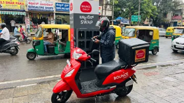 Bounce Daily electric scooter at battery swapping station in Bangalore with delivery bag mounted
