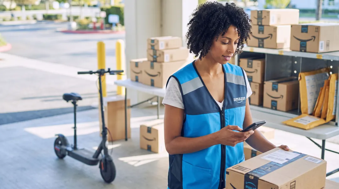 Amazon Flex delivery partner using smartphone app to scan packages at fulfillment station