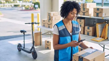 Amazon Flex delivery partner using smartphone app to scan packages at fulfillment station