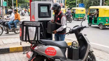 Bounce Daily electric scooter at battery swap station with delivery partner exchanging battery