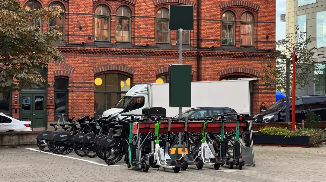 Electric scooter rental hub with EV fleet parked and charging at urban location