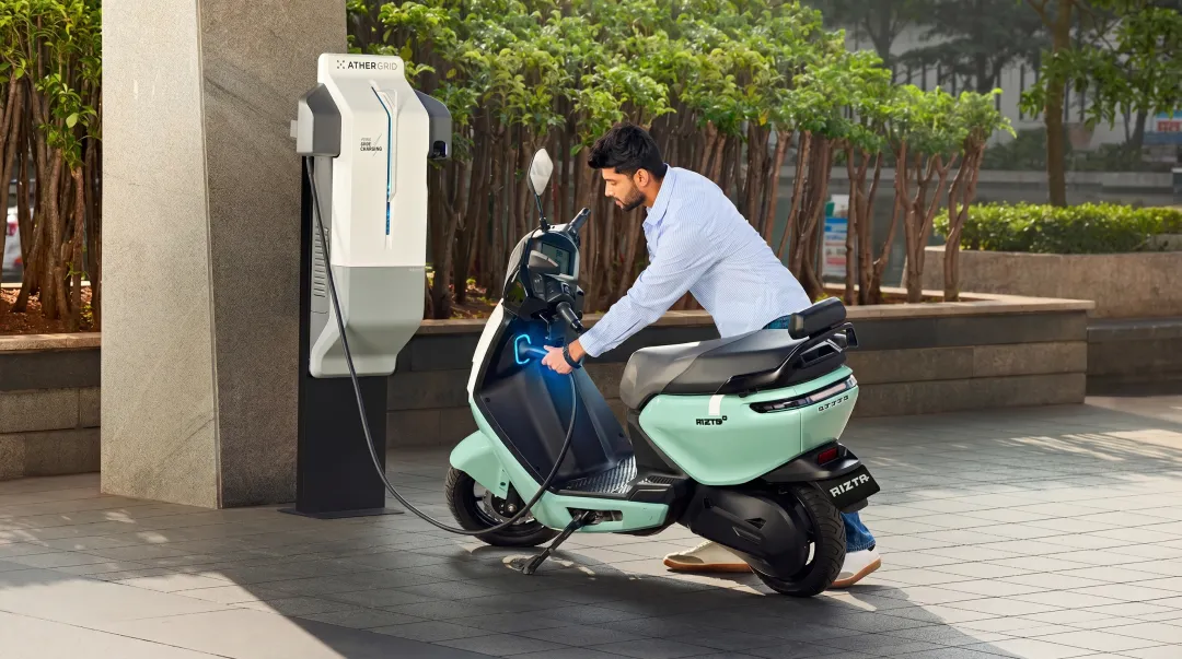 Ather Grid fast charging station with electric scooter plugged in urban setting
