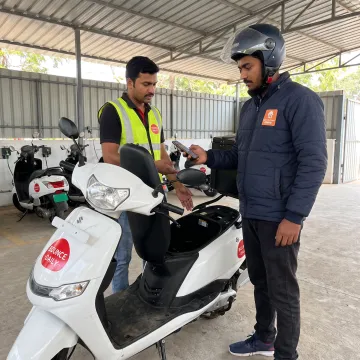 Rider collecting EV scooter at a hub
