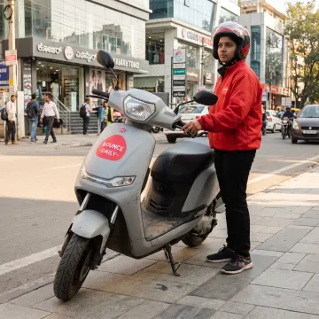 Woman delivery partner beside an electric scooter