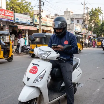 Delivery rider using a smartphone in Hyderabad