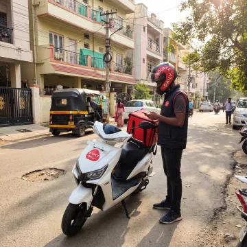 Delivery rider using an electric scooter