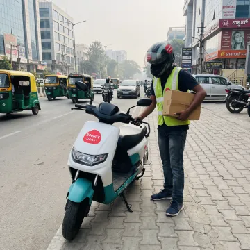 Delivery rider using an electric scooter