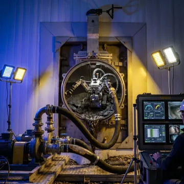 Industrial tank cleaning robot removing sludge from a storage tank