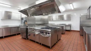 Commercial kitchen interior showing stainless steel surfaces quarry tile floors and FRP walls