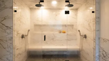 Luxury home steam shower enclosure with glass door and modern tile walls