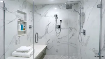 Luxury walk-in shower conversion with frameless glass enclosure and premium tile finishes