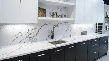 Two-tone kitchen cabinets with white uppers dark lowers and veined quartz countertops