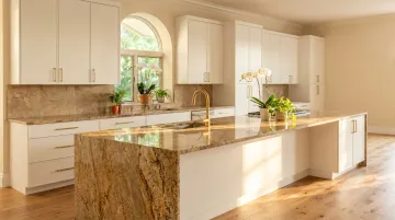 Warm gold granite countertop on white flat-panel cabinets with natural light kitchen