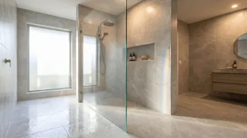 Curbless frameless glass walk-in shower with continuous floor plane and rainfall head