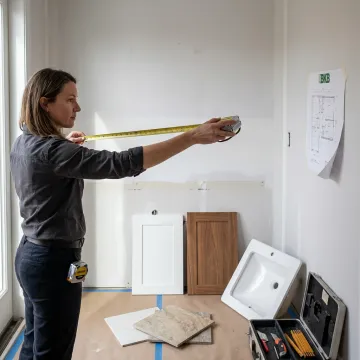 Installer measuring wall hung bathroom vanity