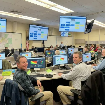 Emergency operations center with first responders conducting strategic risk assessment using advanced incident management technology