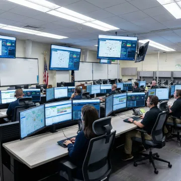 Emergency call management system command center with multiple displays showing incident data