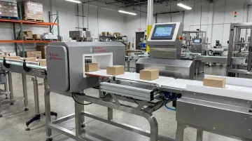 Combination checkweigher and metal detector unit inspecting packaged products on conveyor