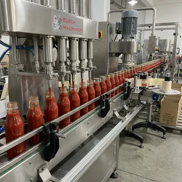 Sauce bottles moving through automated filling line