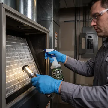 HVAC technician inspecting a clean evaporator coil